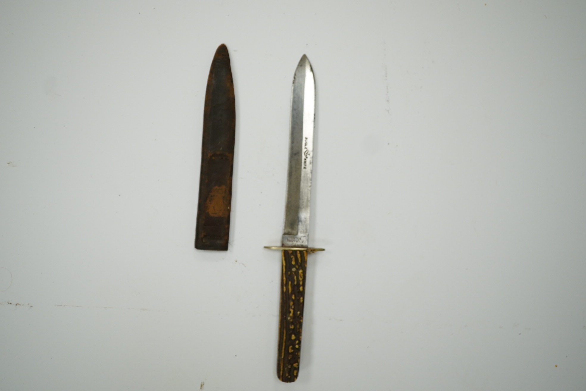 A Hunter of Sheffield, ‘Bugle Knife’ with horn grips, in its leather sheath, blade 15cm. Condition - fair